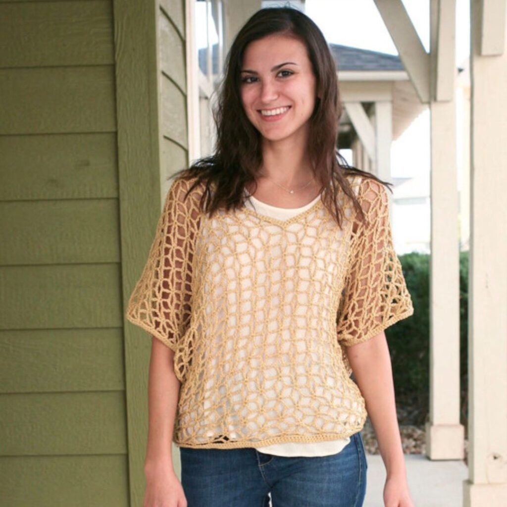Woman wearing a yellow crochet mesh T-shirt over a white tank top. The mesh is loose and the holes are larger.